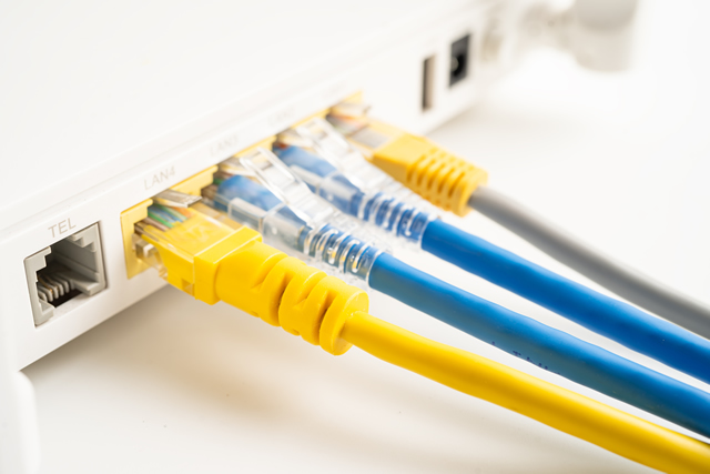 Netwerkbekabeling met Ethernet-kabels aangesloten op een router, illustrerend de professionaliteit van Siegers Technics in netwerkbekabelingsoplossingen.